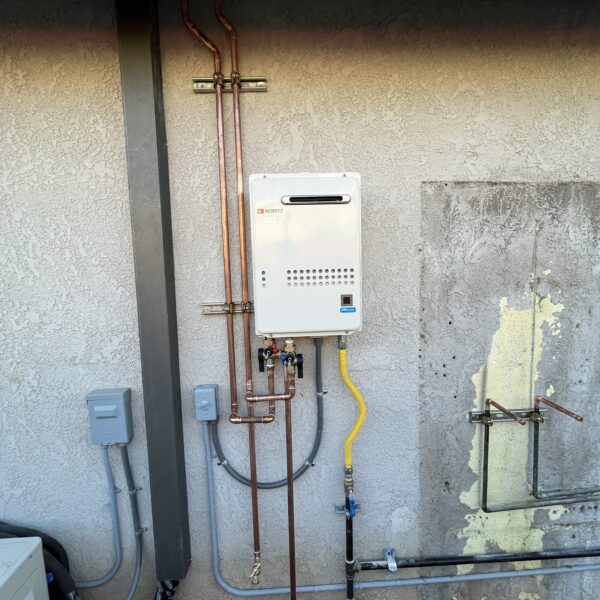 Tankless water heater installed on the exterior wall of a home