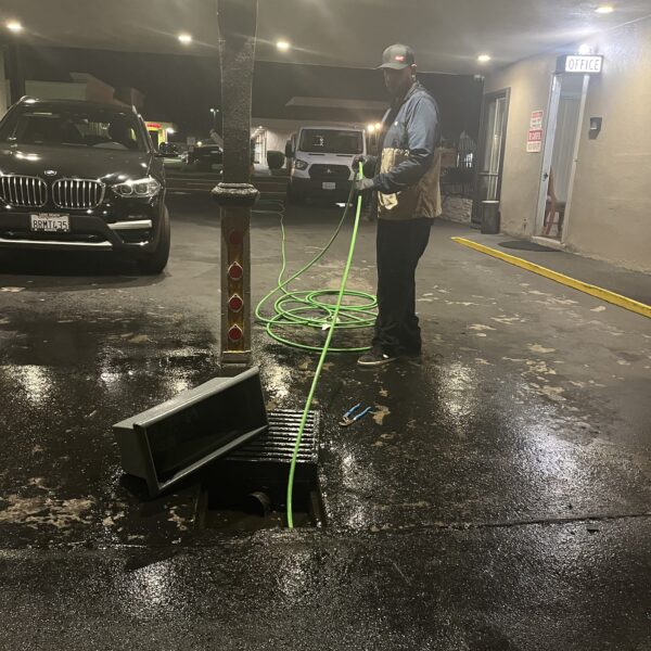 Plumber running a video camera inspection in a parking garage drain